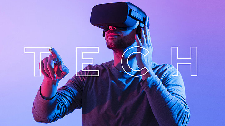 Photo of a man wearing VR goggles. In front of it is the word "TECH".