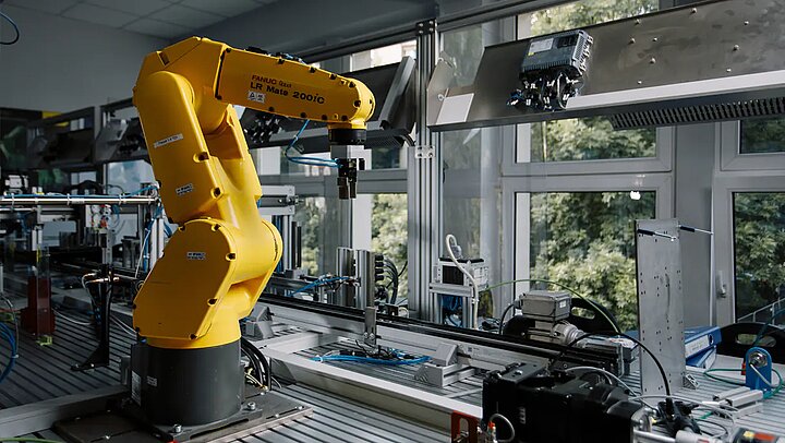 Picture of an yellow industrial robot. 